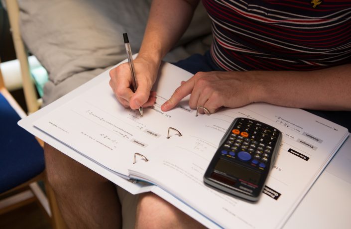 A prisoner studying a Maths distance learning course in his room.